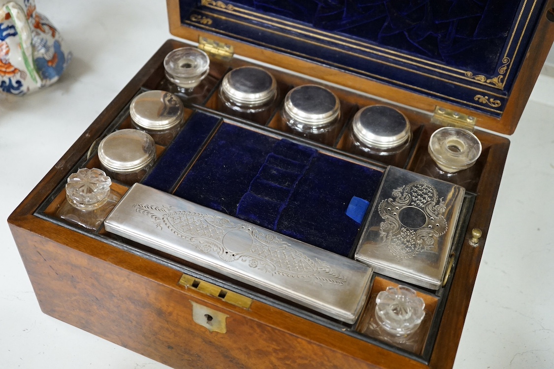 A Victorian walnut lady's toilet box with fitted interior, containing nine bottles, two glass boxes, removable sections, a hidden drawer, etc., together with two mahogany tea caddies. Condition - fair to good.